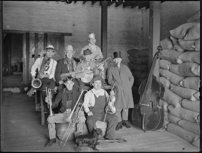 10187Musical band with instruments near grain sacks in a barn or warehouse c1932