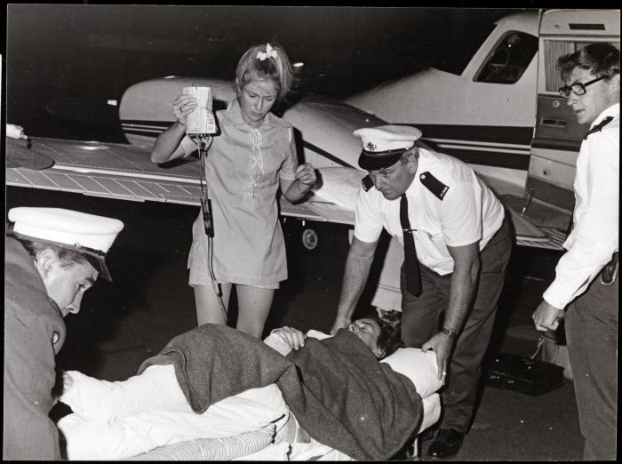 BA27492134 Robin Miller unloading a patient from a Royal Flying Doctor Service Duke aircraft at Port Hedland 1969