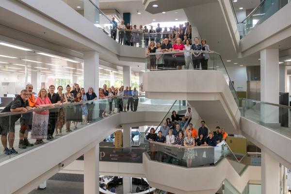 Group photo of staff on library building internal stair case