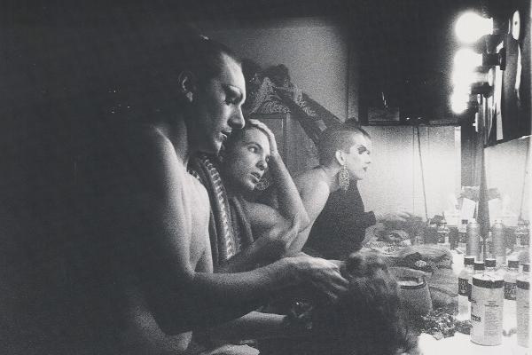 Black and white photo of performers in makeup backstage