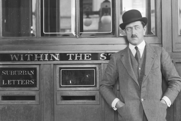 Man in suit beside letterbox c1930