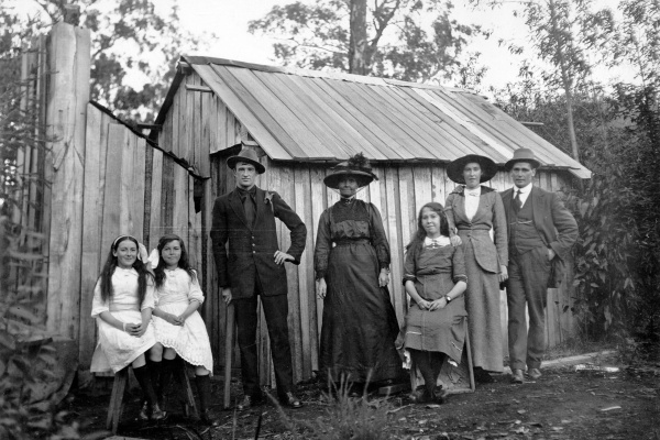 Settlers in front of a bush hut made from sawmill offcuts 1920s