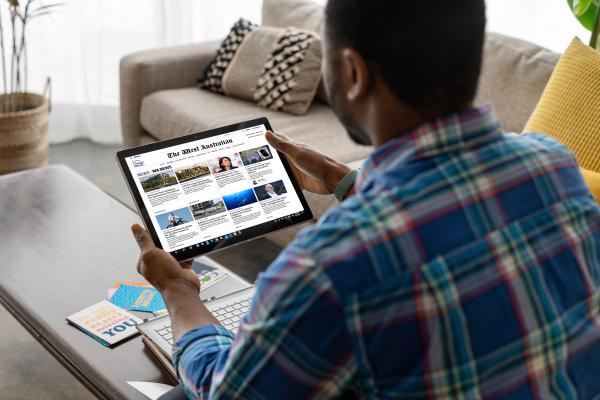 Person reading The West Australian on a tablet screen