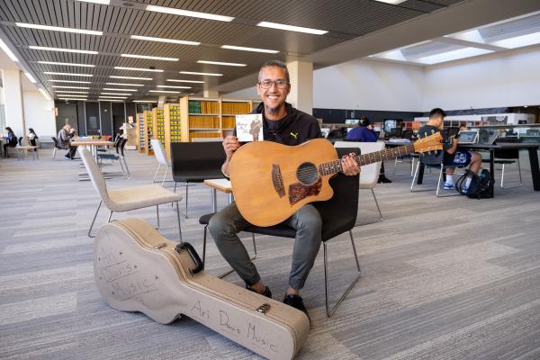 Ari Davis Musician Holds his CD in the State Library