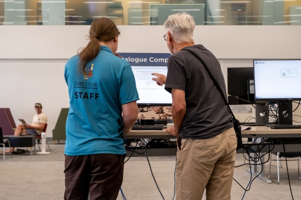 Staff helping client with Catalogue computer