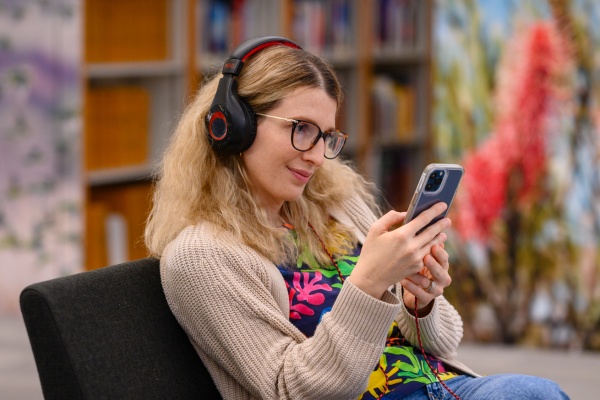 Women listening to music on headphones with a smart device