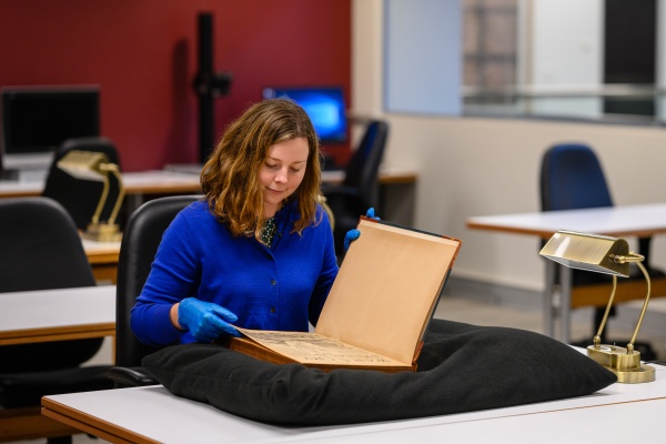 Looking at a historical book in the Leah Jane Cohen Reading Room