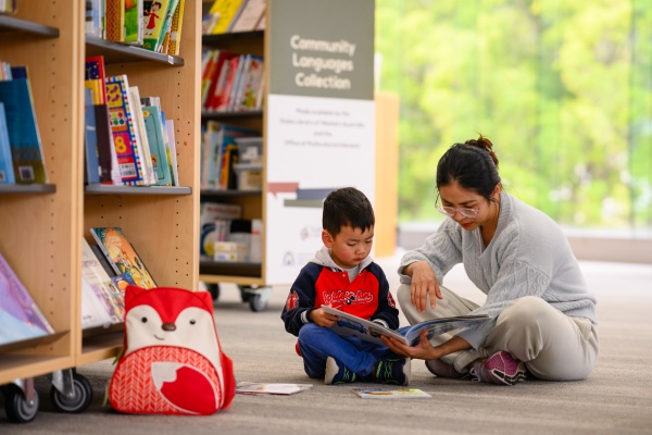 Parent and child reading a book from the Community Languages Collection