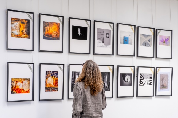 Person looking at photographs in the 2024 Ilford Orloff Awards exhibition