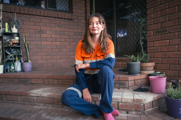woman in high vis fear sitting on brick steps