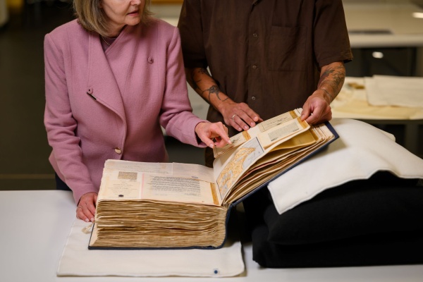 Two people examining a vintage book