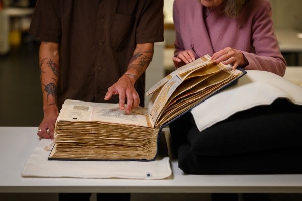 Two people examining a vintage book