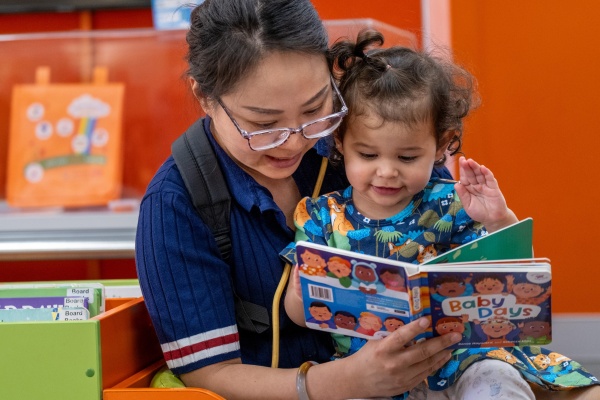 woman reads Baby Days book to child