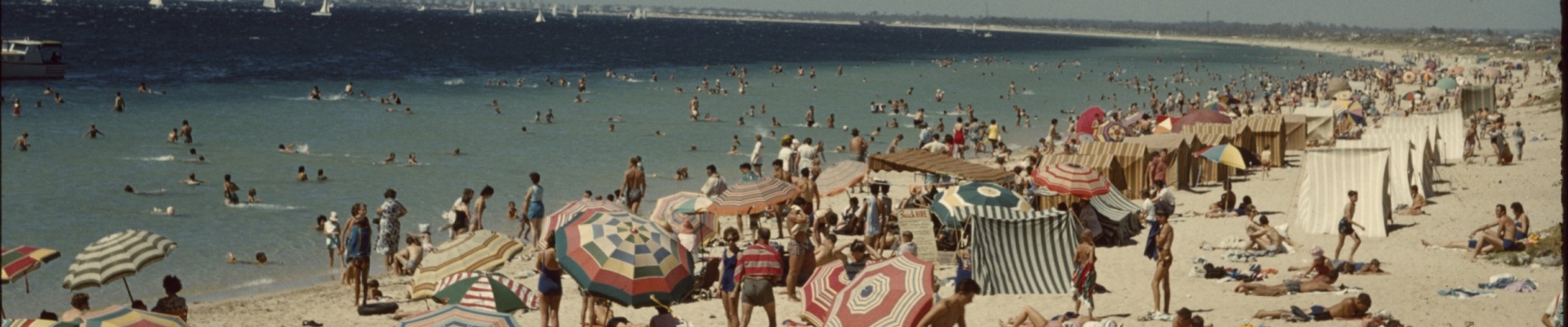 A crowd on Rockingham Beach with the Rockingham Yachting Carnival offshore 1961
