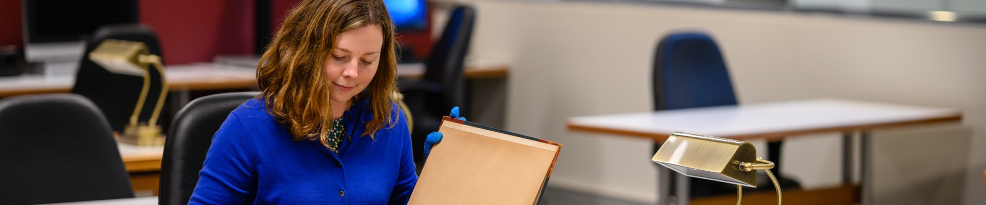 Looking at a historical book in the Leah Jane Cohen Reading Room