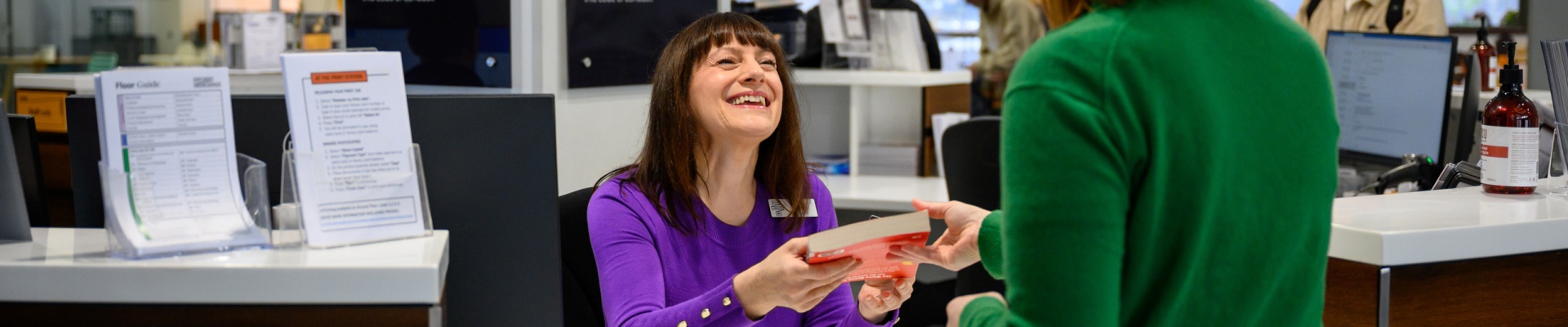 staff member handing a client a book