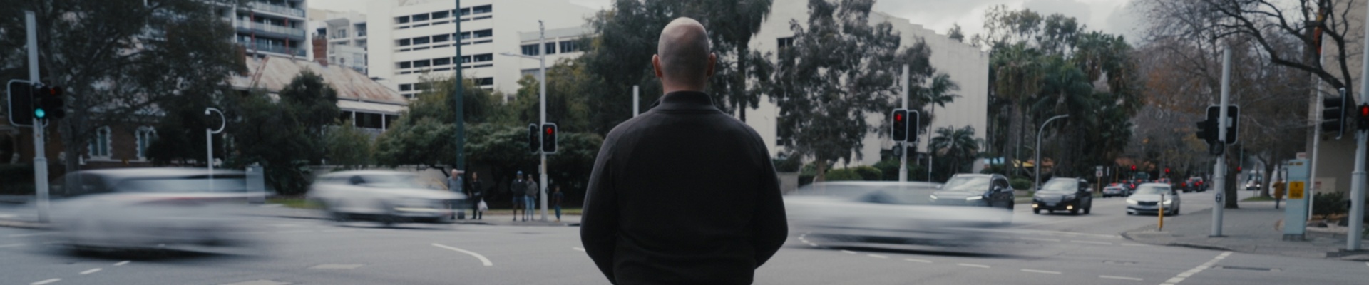 man and his guide dog facing a busy intersection