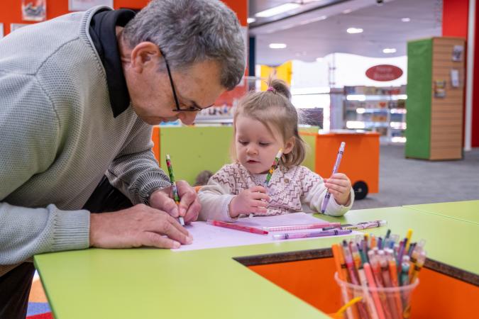 Child drawing with her grandfather
