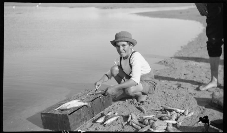 Boy cleaning fish image Izzy Orloff