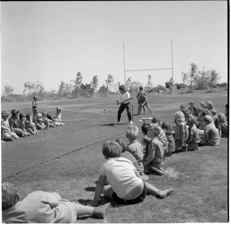 Rod Marsh demonstrates batting technique to boys from Dampier Karratha Roebourne and Wickham at Dampier Primary School 1973
