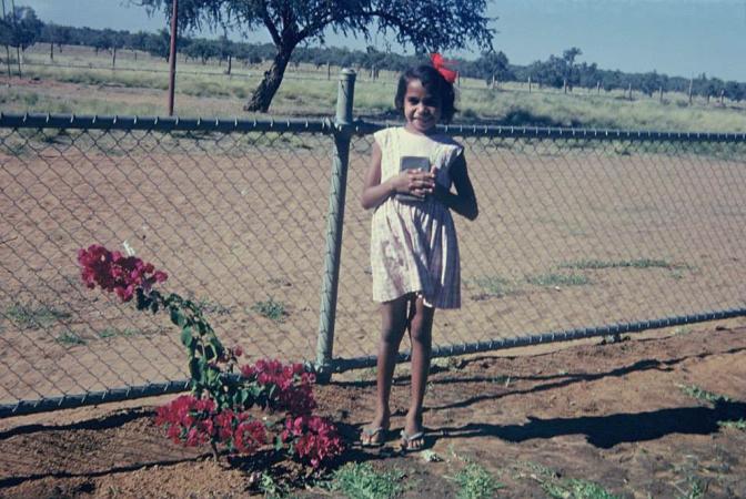 Young girl standing by flowers