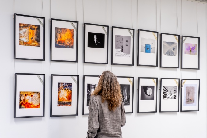 Person looking at photographs  in the 2024 Ilford Orloff Awards exhibition