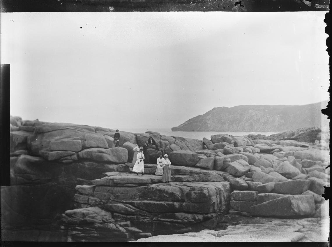 021686PD Group climbing granite rock formation on the coast near Albany ca 1905