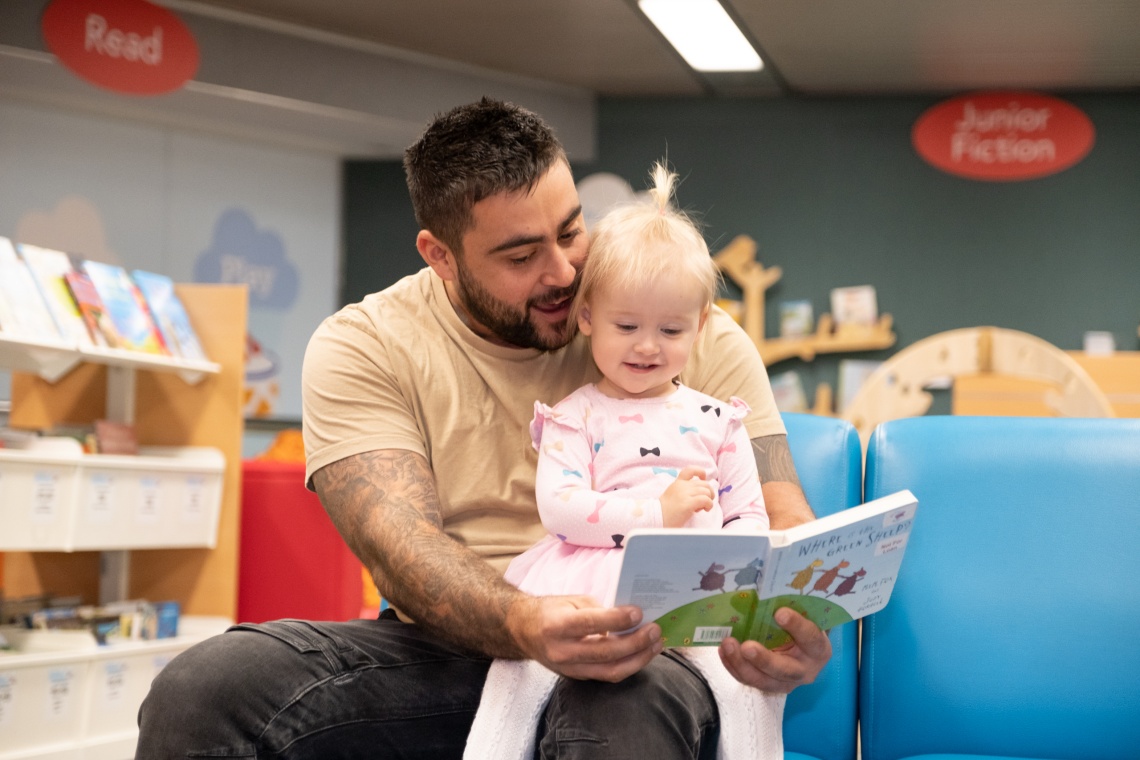 Father reading to daughter