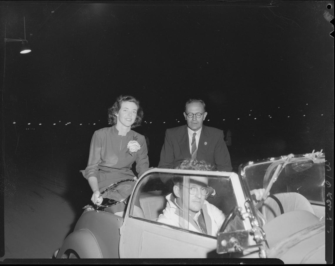 Winifred Wells is driven around Claremont Speedway after being presented with a silver tray engraved with a map of her journey around Australia 1953