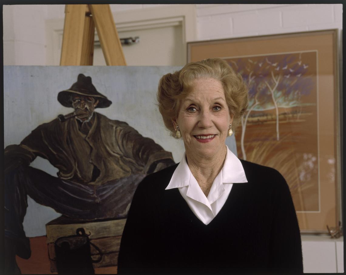 woman in front of a painting on an easel 