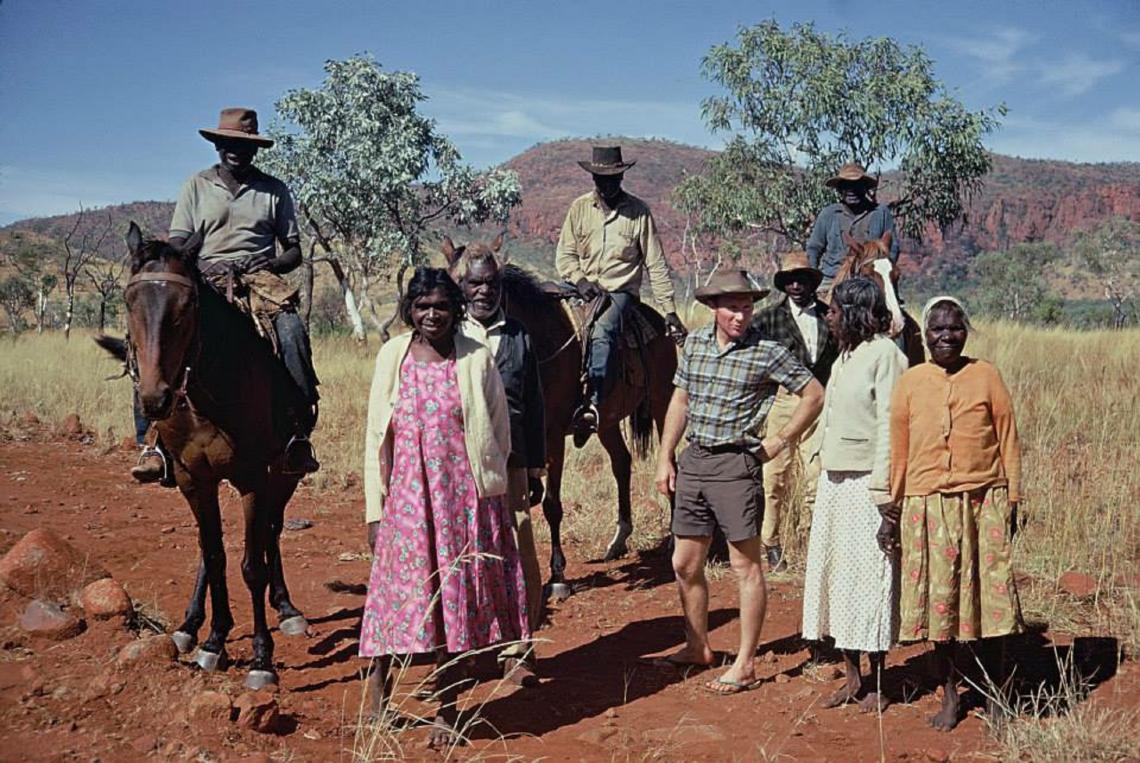 Men on horseback with family beside them