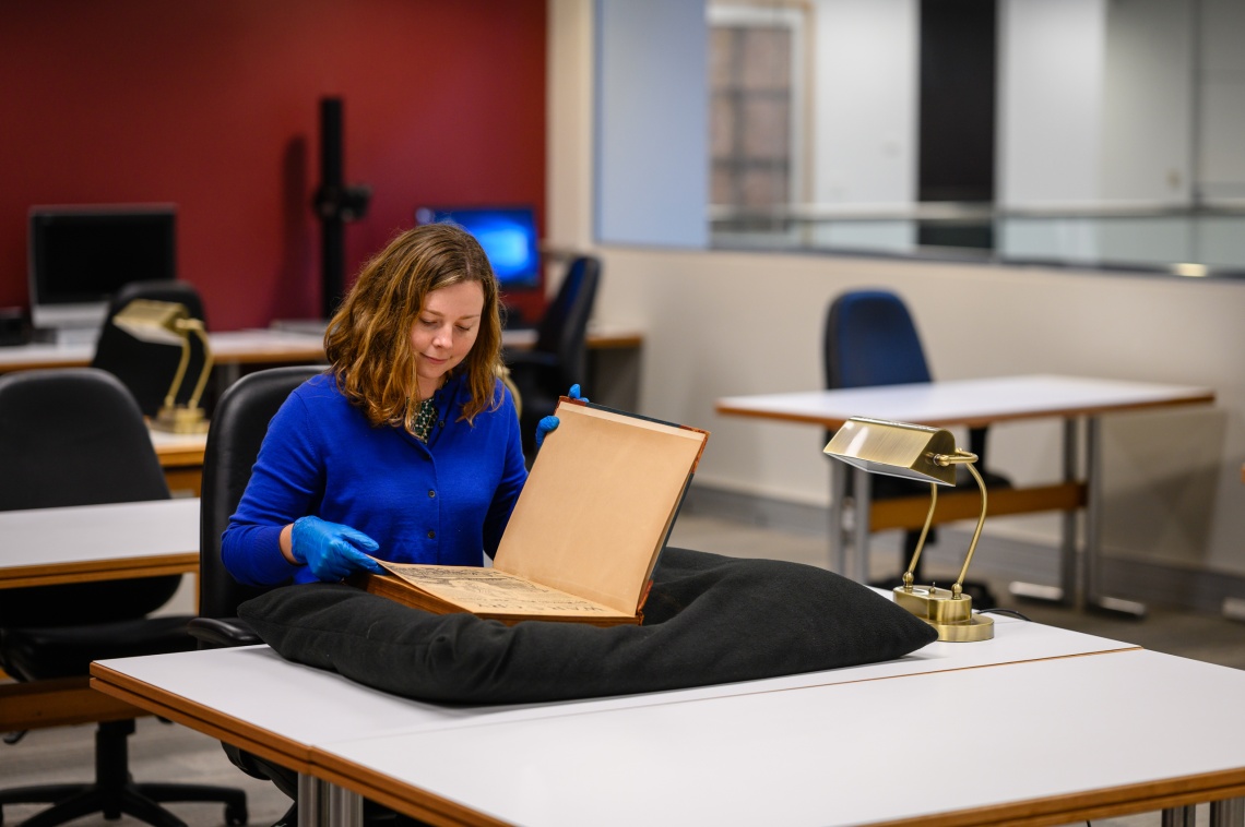 Looking at a historical book in the Leah Jane Cohen Reading Room