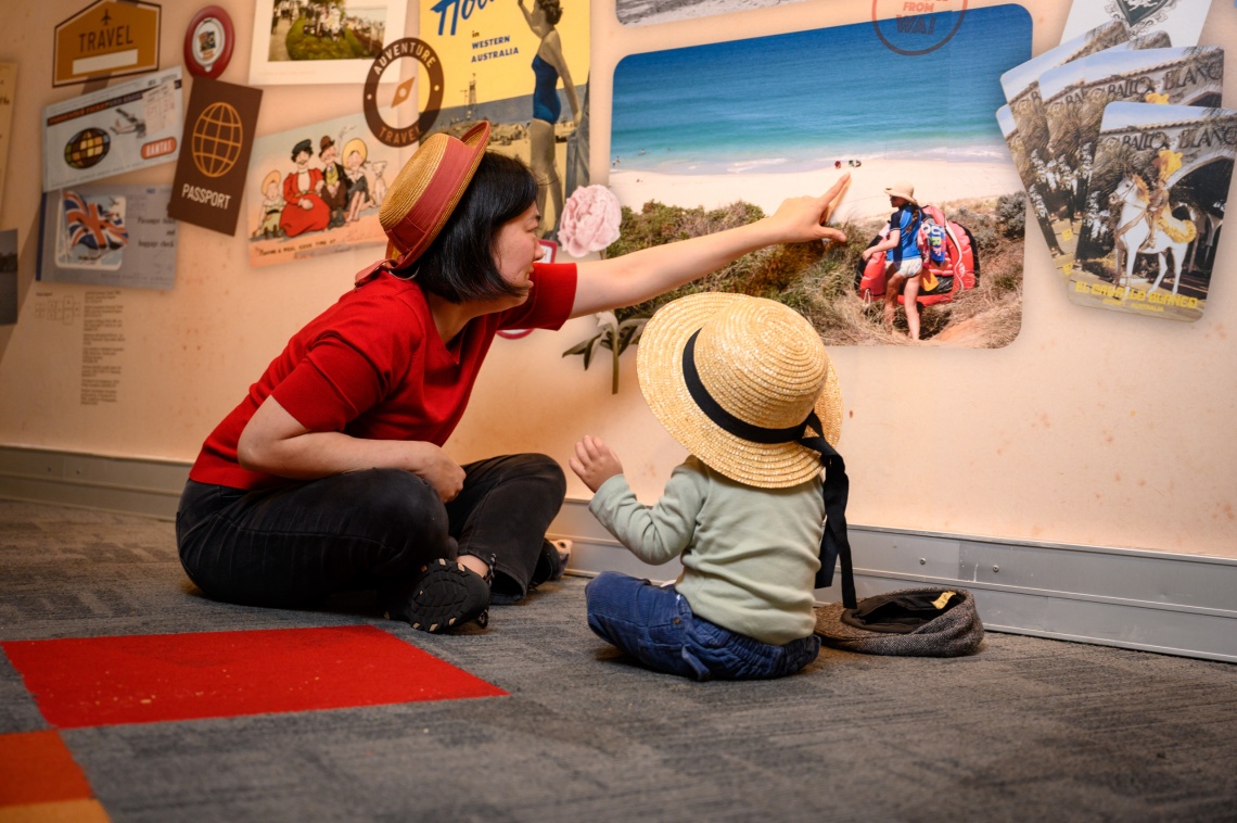 Mum and child looking at beach photo in the Keepsake Exhibition 2024