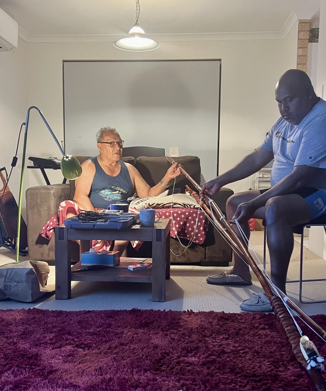 Fofo Poasa left and Himona Poasa right attaching the pa hi atu skip jack fishing lure on to a traditional Tokelauan fishing rod kofe 