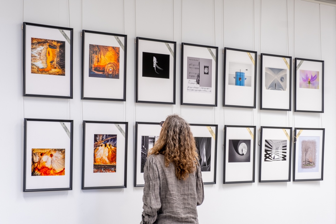 Person looking at photographs  in the 2024 Ilford Orloff Awards exhibition
