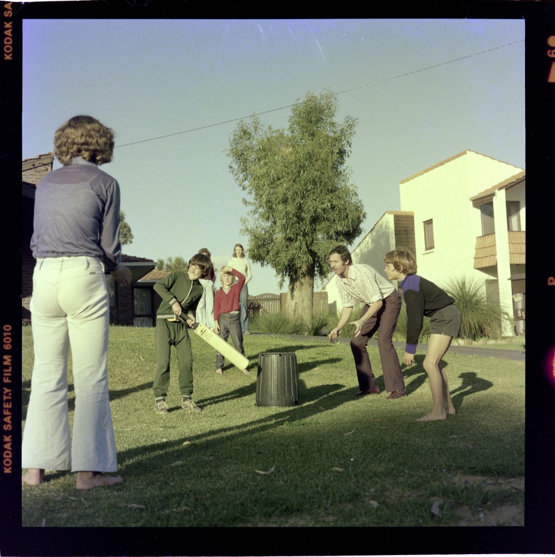 Family playing backyard cricket 14 August 1975