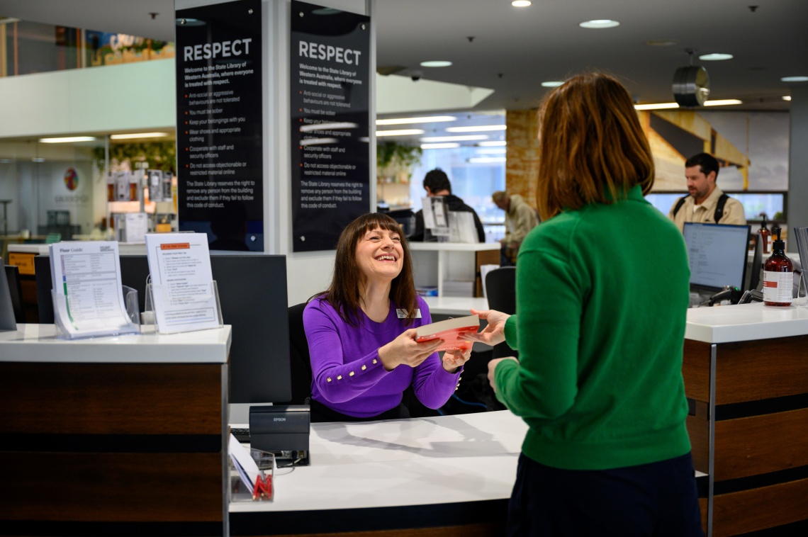 staff member handing a client a book