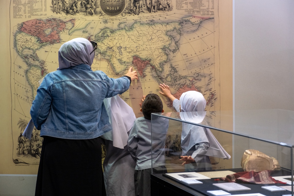 Adult and children looking at the Sheiks Fakes and Cameleers exhibition 2025