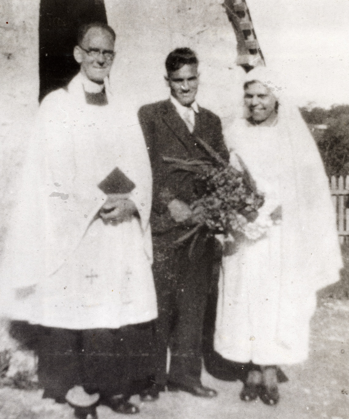 Aboriginal couple at Moore River at their wedding reverend beside them