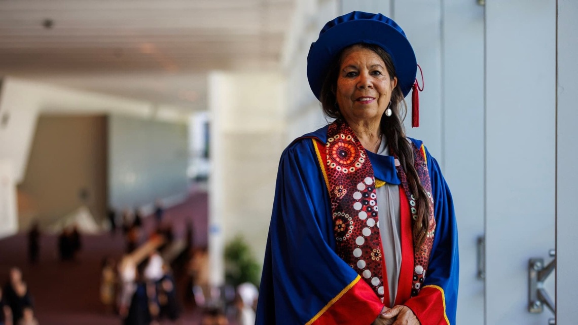 Dr Charmaine Papertalk Green Smith in PHD graduation hat and gown