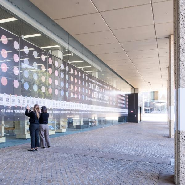 People scanning QR codes on the Alexander Library building