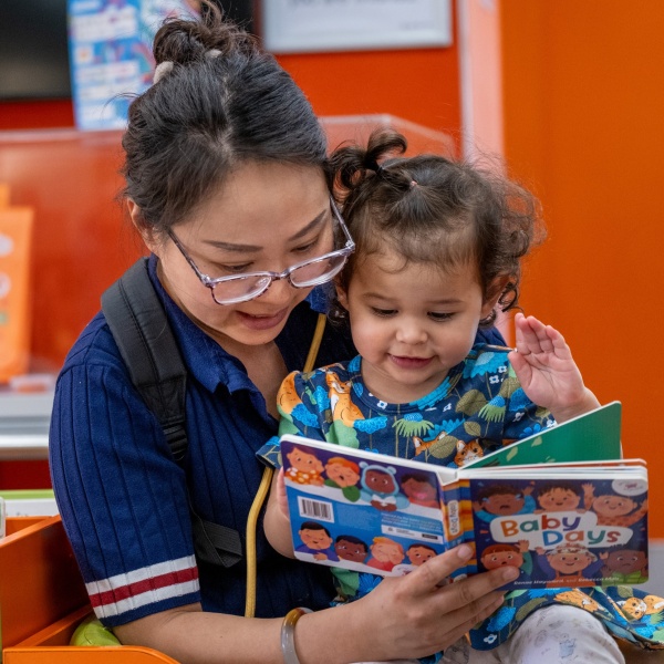woman reads Baby Days book to child