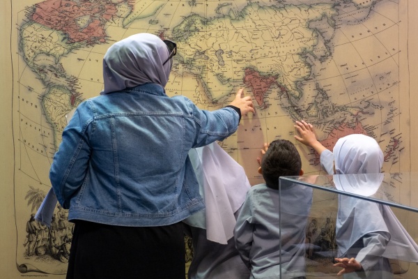 Adult and children looking at the Sheiks Fakes and Cameleers exhibition 2025
