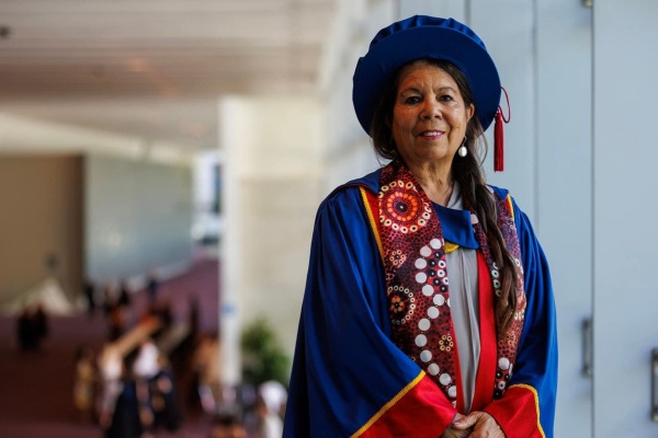 Dr Charmaine Papertalk Green Smith in PHD graduation hat and gown
