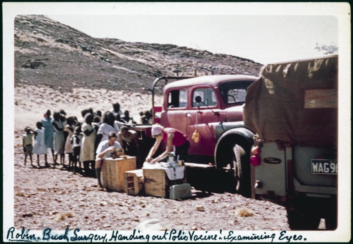 BA27492127 Robin Miller handing our polio vaccine and examining eyes at a bush surgery on Don McLeods property West Wodgina Hills in the North-West tin mine 1967