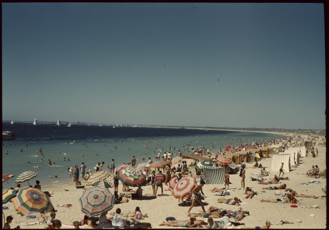A crowd on Rockingham Beach with the Rockingham Yachting Carnival offshore 1961