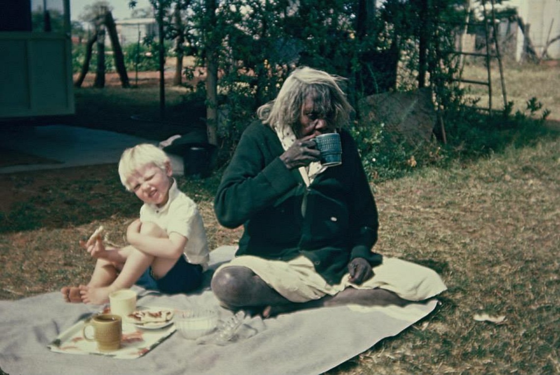 Women sharing a meal with a boy on the grass