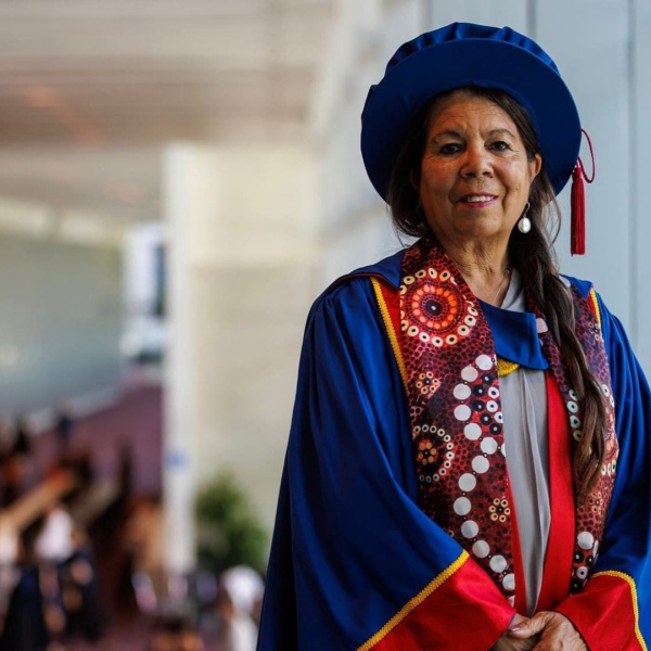 Dr Charmaine Papertalk Green Smith in PHD graduation hat and gown
